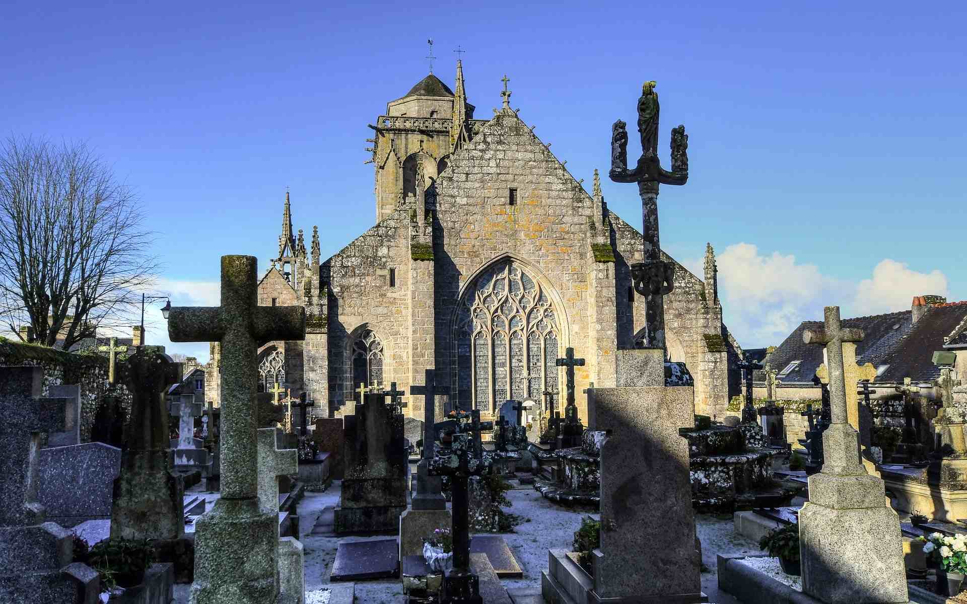 L’église Saint-Ronan et son cimetière. Au premier plan, les tombes formant le cimetière de Locronan. En arrière-plan, l’église Saint-Ronan dans la lumière du soleil.