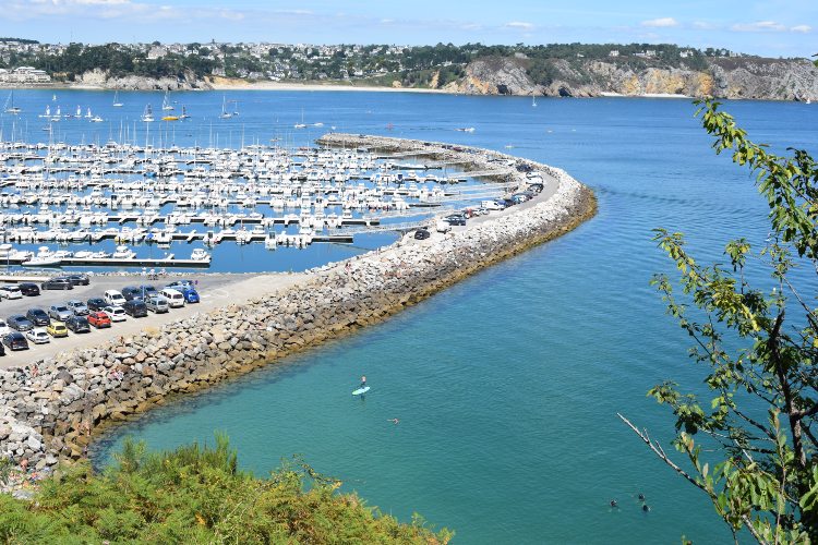 Vue sur la baie de Douarnenez et le port de Crozon Morgat, sur le GR34.  Des grottes marine sont visibles en arrière plan.