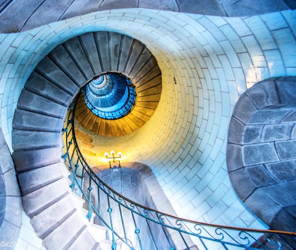 Vue contre-plongée de l'intérieur du phare d'Eckmühl à Penmarch. L'escalier en colimaçon monte jusqu'en haut.