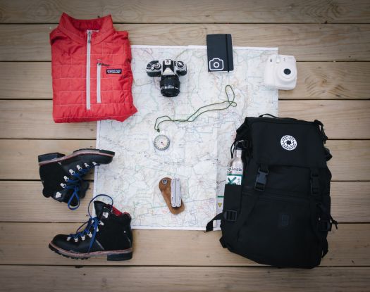 Équipement pour la randonnée en Bretagne avec des chaussures, une carte, une boussole et un appareil photo