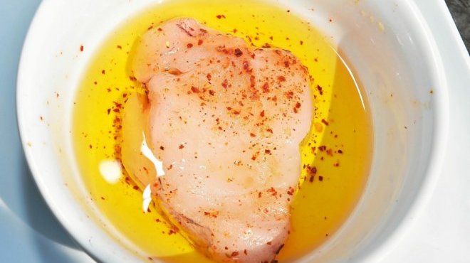 Un peu d’huile d’olive, de sel et du piment d’Espelette pour faire mariner la lotte.  (Photo Claude Prigent / Le Telegramme)