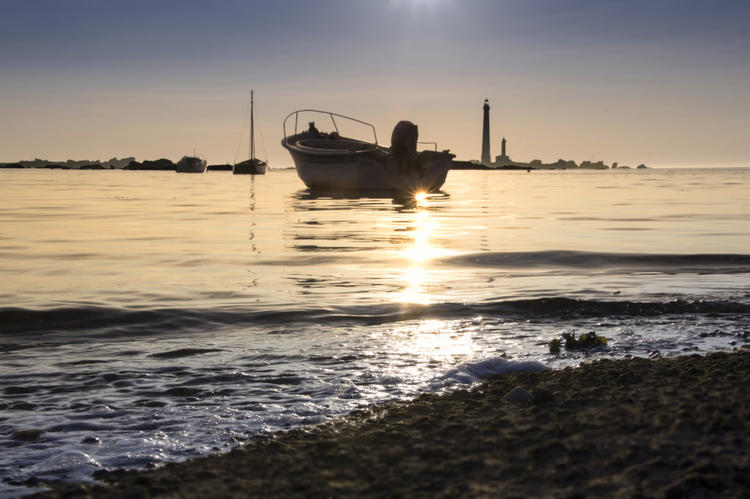 Couché de soleil proche du phare de l'île vierge Reflet du couché de soleil sur la mer et un bateau