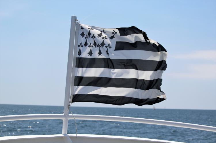 Le Gwenn ha Du, le drapeau breton blanc et noir, flotte au vent avec la mer en fond