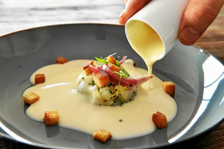 Un délicieux chaud-froid mêlant tartare de Saint-Jacques et velouté de chou-fleur.