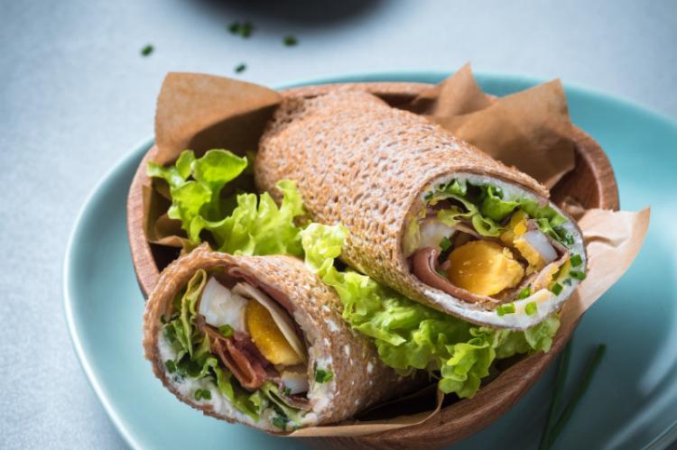 deux wraps de galettes de blé noir composé de jambon cru, de fromage frais et des oeufs Wraps de galettes de blé Noir au jambon cru, fromage frais & œufs