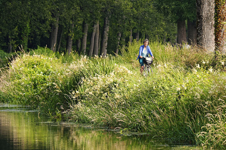 La journaliste de Bretagne Magazine sur les bords du canal de Nantes à Brest Cycliste sur les bords du canal de Nantes à Brest