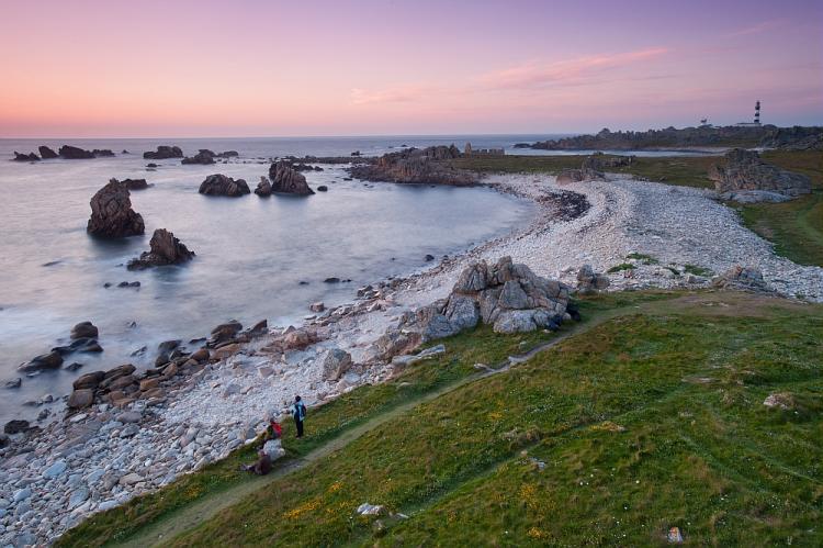 Vue sur l'île d'Ouessant, phare du Creac'h et pointe de Pern au crépuscule, au coucher du soleil.