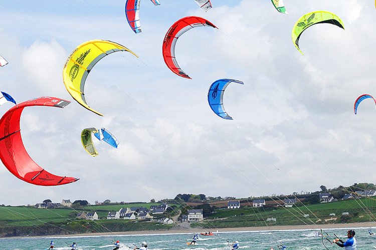 Homme faisant du kitesurf sur la mer avec d'autre surfeurs