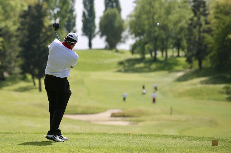 Joueur de golf tirant avec son drive sur un terrain de golf Joueur de golf de la Ligue de Bretagne tirant avec son drive sur un terrain de golf