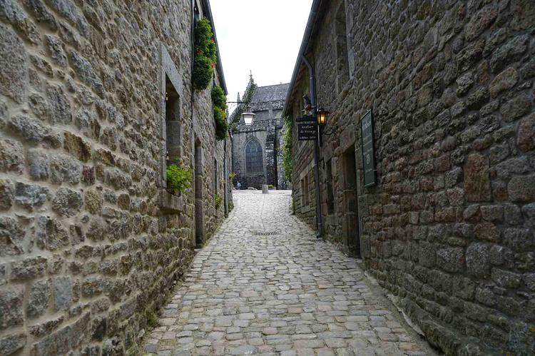Ruelle proche de la rue des Charrettes à Locronan. ruelle étroite à Locronan. Les maison sont en pierre serrées. Le sol est pavé.Au bout de la ruelle, on aperçoit l’église de Locronan.