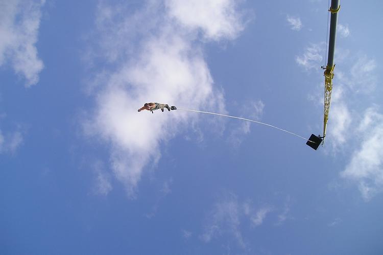 Homme se jetant d'une grue pour effectuer un saut à l'élastique 