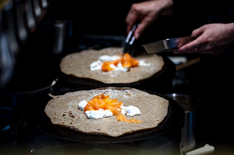 Préparation d'une galette au saumon dans la crêperie Breizh Café à Paris