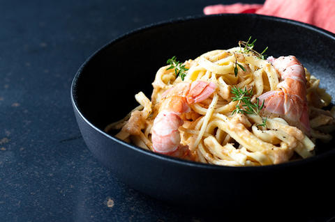 Tagliatelles au beurre de langoustines dans une belle assiette creuse noire 