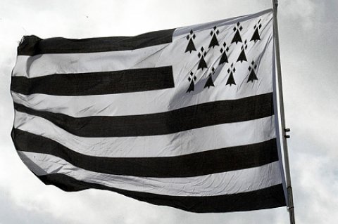 Le Gwenn ha Du, le drapeau breton blanc et noir, flotte au vent avec la mer en fond