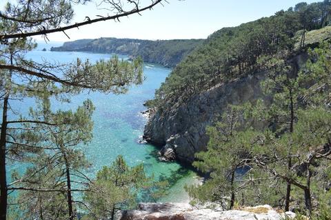 Le GR34 à Crozon, en Bretagne. photo prise en été 2020. Le littoral de la baie de Douarnenez prise depuis une falaise surplombant une crique dans laquelle des kayakiste bronzent.